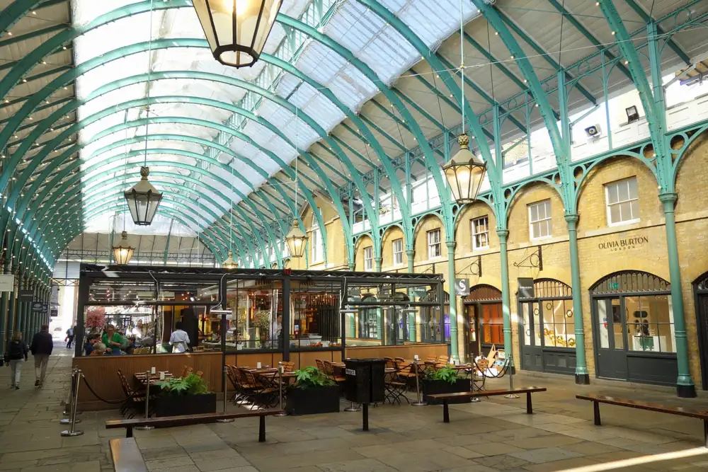 Glass-roofed Covent Garden Market hall with hanging lanterns, close to our Covent Garden massage London studio